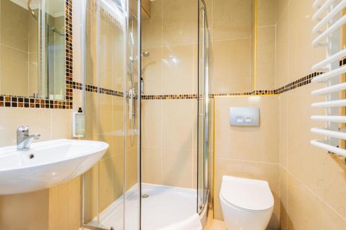 a bathroom with a shower and a toilet and a sink at Noclegi Stadion Bed & Breakfast in Warsaw