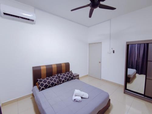 a bedroom with a bed and a ceiling fan at Spacious Family House at Desaru Harmonia 2 in Desaru
