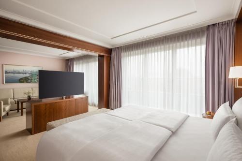 a hotel room with a bed and a flat screen tv at GRAND ELYSEE Hamburg in Hamburg