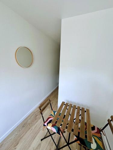 une chaise en bois dans une chambre avec un miroir mural dans l'établissement New studio very close to Roland Garros & Parc des Princes 1 room, à Boulogne-Billancourt