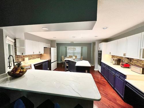 a large kitchen with white cabinets and a counter top at Wellington Pool House With Spa and Putting Green in Wellington