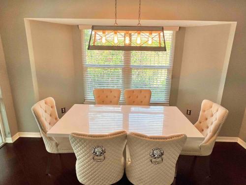a dining room table with chairs and a window at Wellington Pool House With Spa and Putting Green in Wellington