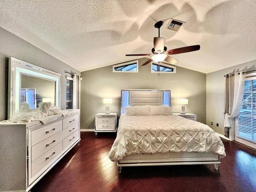 a bedroom with a bed and a ceiling fan at Wellington Pool House With Spa and Putting Green in Wellington