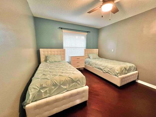 a bedroom with two beds and a ceiling fan at Wellington Pool House With Spa and Putting Green in Wellington