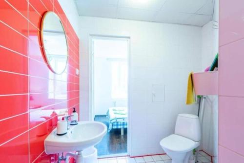 a pink bathroom with a sink and a toilet at Cozy Apartments in Kudjape