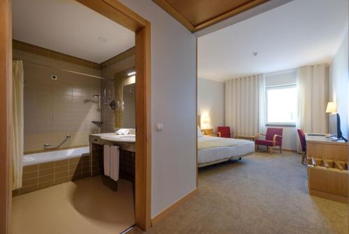 a hotel room with a bed and a bathroom at Hotel Santa Maria in Fátima