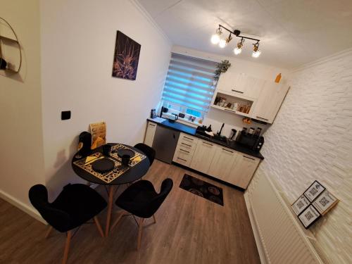 a kitchen with a table and chairs in a room at Black Diamond Lux - deluxe riverside apartment in Senta