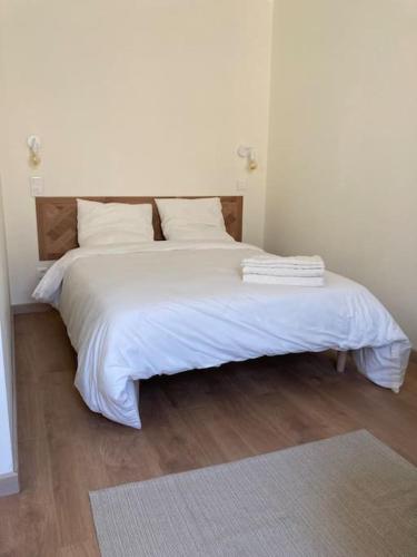 - une chambre dotée d'un lit blanc avec des draps et des oreillers blancs dans l'établissement Hyper centre - Ecusson, à Castres