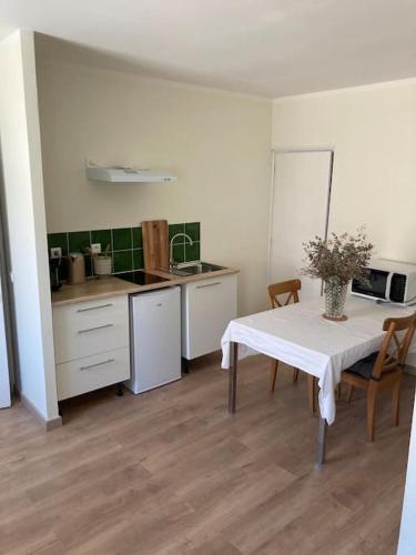 une cuisine avec une table avec un vase dessus dans l'établissement Hyper centre - Ecusson, à Castres