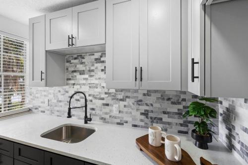 a kitchen with white cabinets and a sink at Spacious 3br Oviedo Home Save 20 Wi-fi in Oviedo