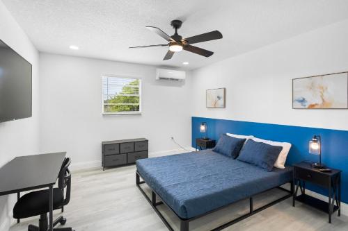 a bedroom with a blue bed and a desk at Spacious 3br Oviedo Home Save 20 Wi-fi in Oviedo