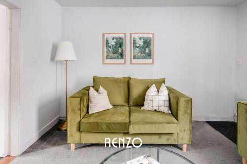 a living room with a green couch with pillows at Gorgeous 2-bed Home in Newark on-Trent by Renzo, Free Parking, Brilliant Location! in Newark upon Trent