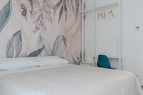 ein Schlafzimmer mit einem weißen Bett und einer Blumenwand in der Unterkunft Relais del Parco Azzurro e Relais del Parco Rosa in LʼAquila