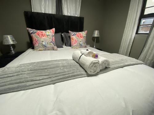 a bedroom with a bed with towels and pillows at Fish Eagle Place in Durban