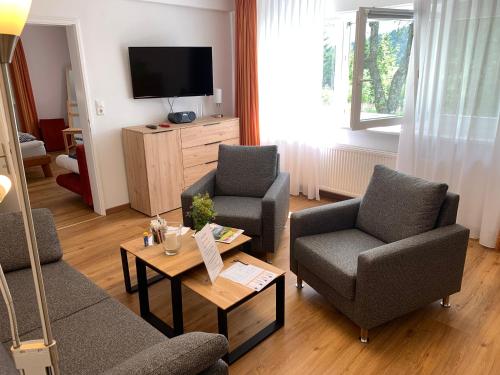 a living room with two chairs and a tv at Ferienwohnung Heimweg in Feldberg