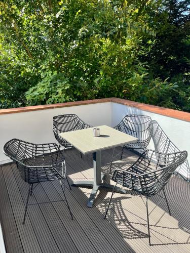a table and three chairs on a deck at STADtPERLE in Itzehoe