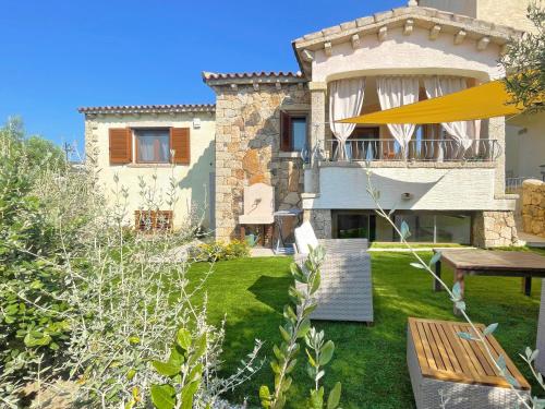a house with a yard with a bench and a table at Villa del Golfo in Olbia