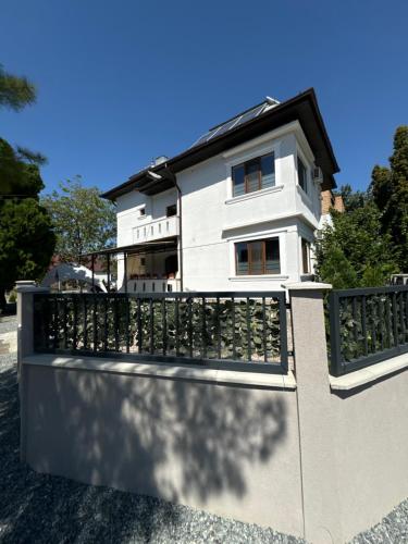 a white house behind a fence at Excelsior INN in Turda