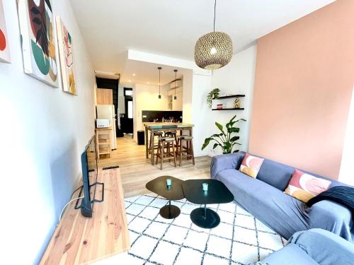 Una sala de estar con un sofá azul y una mesa. en Agathoise by Yumē, en Toulouse