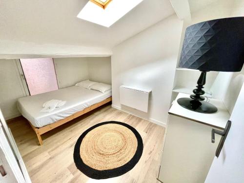 Una pequeña habitación con una cama y una ventana. en Agathoise by Yumē, en Toulouse