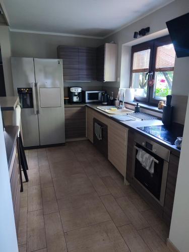 a kitchen with stainless steel appliances and a tile floor at FORREST DOM w LESIE in Rzędkowice