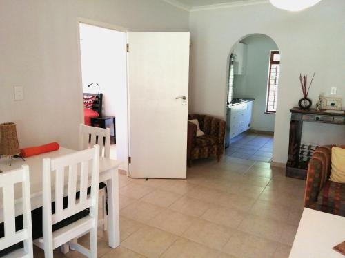 a living room with a table and a dining room at Gästehaus HelderbergView in Somerset West