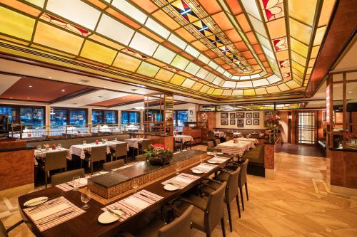 a dining room with tables and chairs in a restaurant at GRAND ELYSEE Hamburg in Hamburg