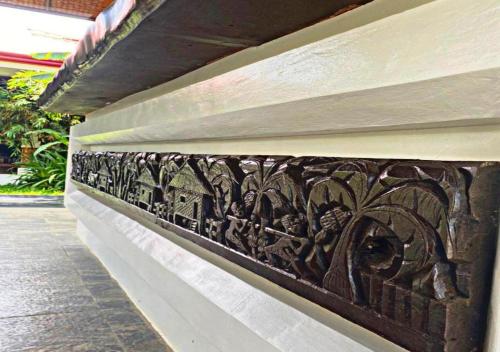 a wall with a carving on the side of a building at Carpe Diem Villas & Resort in Puerto Princesa City