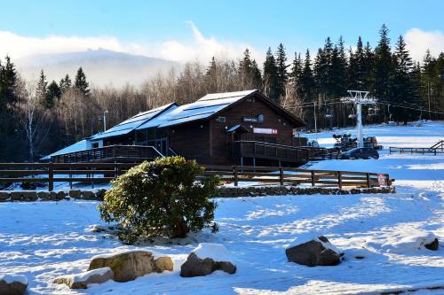 a barn with snow on the ground in front at Hotel Willa Odkrywców in Szklarska Poręba