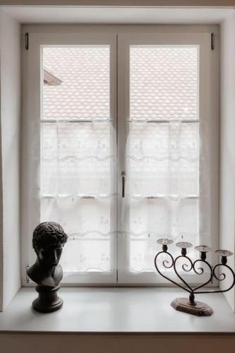 a window with a statue in front of it at Charmant appartement en vieille ville de Morat in Murten
