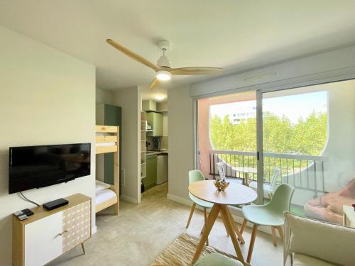 un salon avec un canapé, une télévision et une table dans l'établissement PGH N35 - à 50m de la Plage avec Parking Privé, à La Grande Motte