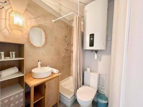une salle de bain avec un lavabo, des toilettes et un miroir dans l'établissement PGH N35 - à 50m de la Plage avec Parking Privé, à La Grande Motte