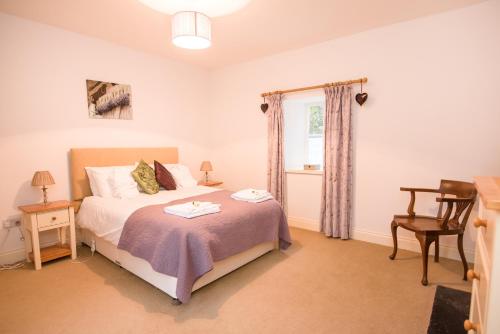 a bedroom with a bed and a desk and a window at Springkell in Eaglesfield