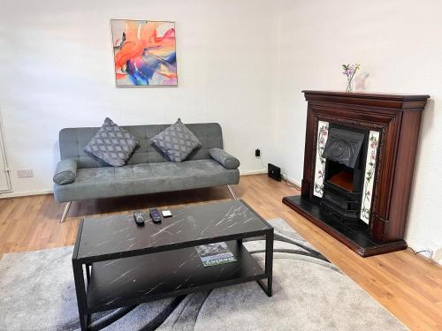 a living room with a couch and a fireplace at Abbey Wood Serviced Apartment 3BRH Free Wi-Fi Parking Tea and Coffee in Belvedere