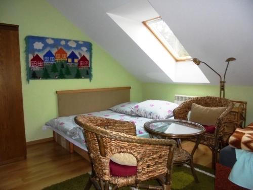 a bedroom with a bed and a table and chairs at Pokoje Gościnne Na Skraju Lasu in Kamieniec Ząbkowicki