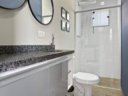 ein Badezimmer mit Toilette, Waschbecken und Spiegel in der Unterkunft Espaçoso Apartamento com Churrasqueira Expo Imig in São Paulo