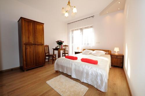 a bedroom with a bed with two red pillows on it at Willa Julia in Krakow