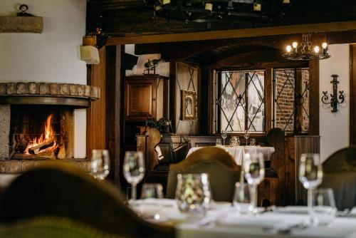 a dining room with a table and a fireplace at Romantik Hotel Hof zur Linde in Münster