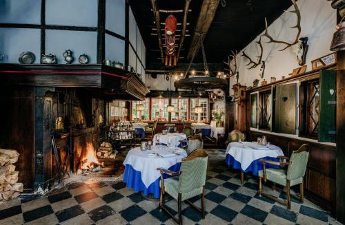 a dining room with two tables and a fireplace at Romantik Hotel Hof zur Linde in Münster