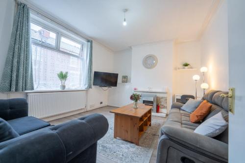 a living room with two couches and a tv at Spacious 5 bedroom house in Rochdale