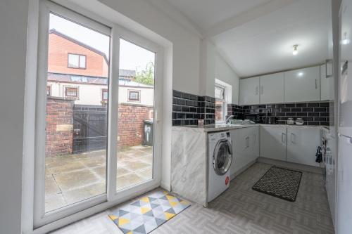 a kitchen with a washer and dryer in a room at Spacious 5 bedroom house in Rochdale