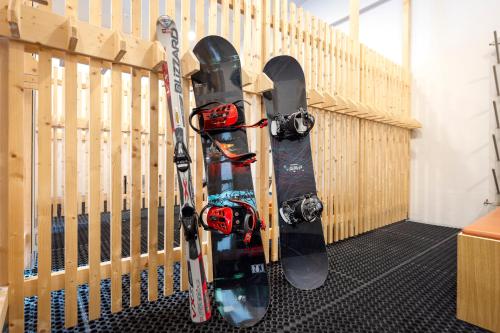 two snowboards and skis are leaned up against a wall at JUFA Hotel Schladming in Schladming
