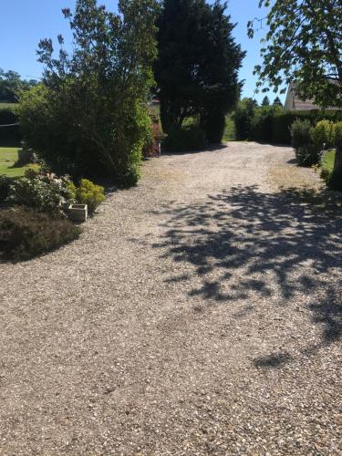 a gravel driveway with trees on the side of a house at Chambres d'hôte du Domaine de la Reine Blanche in Criquetot-sur-Longueville