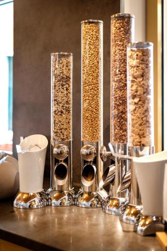 a table topped with four tall glass vases filled with food at JUFA Hotel Schladming in Schladming