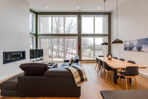 a living room with a couch and a table at L'Orée 145 - Ski-in Ski-out 10 personnes in Beaupré