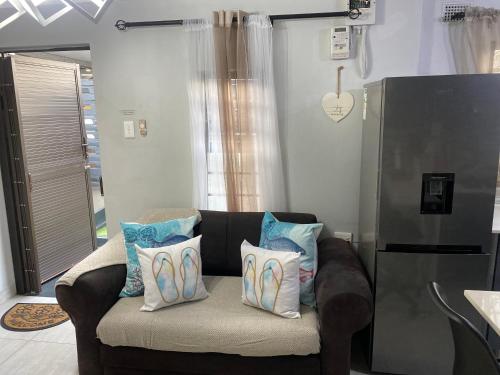 a couch with pillows on it in a living room at Fish Eagle Place in Durban