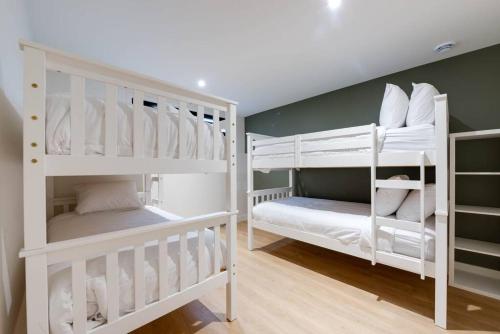 two white bunk beds in a room at L'Orée 145 - Ski-in Ski-out 10 personnes in Beaupré