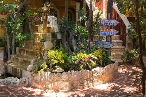 a garden with signs and plants in front of a house at Maison Tulum in Tulum