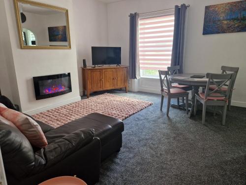 a living room with a couch and a table with a fireplace at Syringa in Lindley