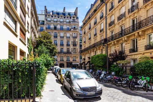 une voiture garée dans une rue en face des bâtiments dans l'établissement The Parisian Dream, à Paris